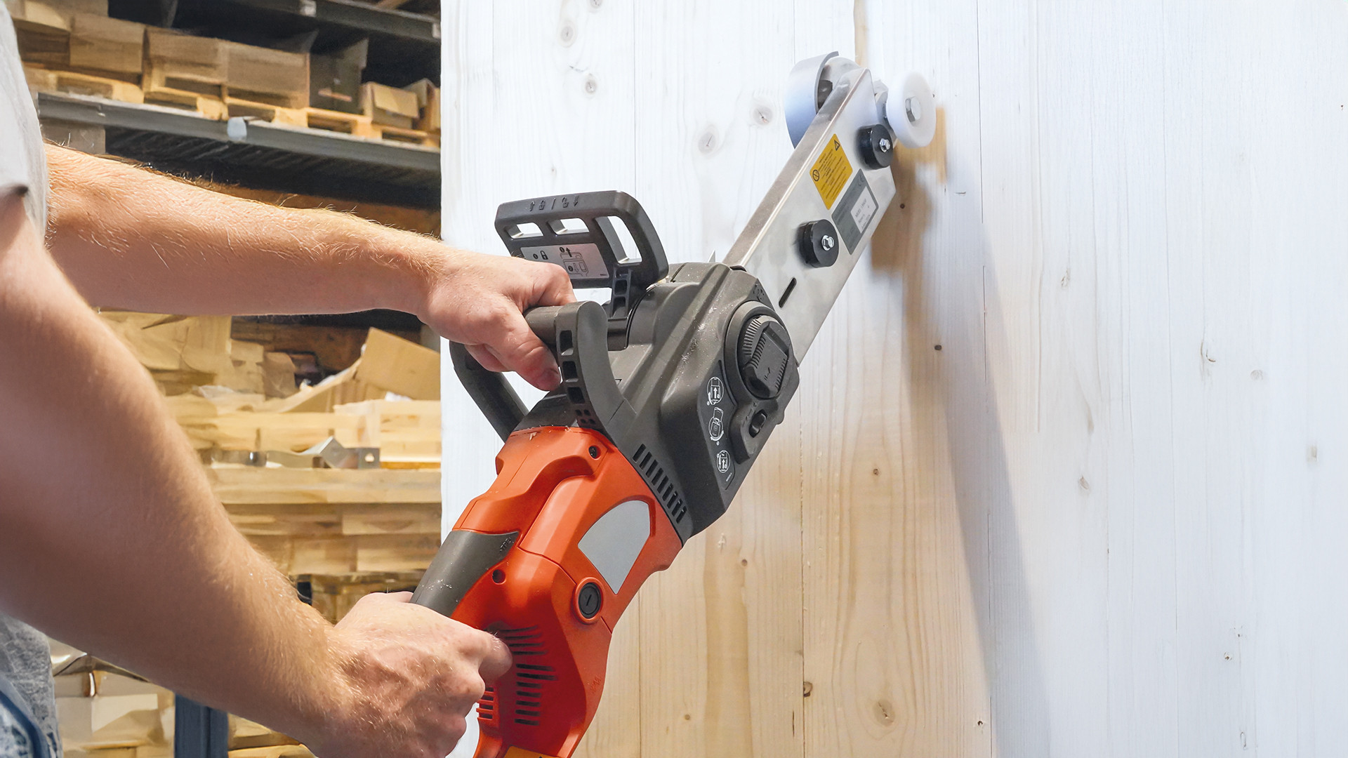 Professional woodworking machine performing a vertical cut on a solid timber panel using a carpentry chainsaw for structural wood processing. 